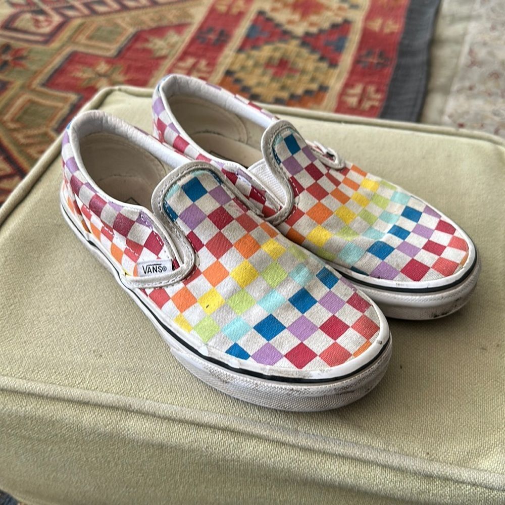 Vans rainbow checkerboard slip-ons.